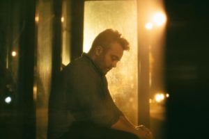 Person steht ruhig und geschützt, während negative Energie im Hintergrund verblasst