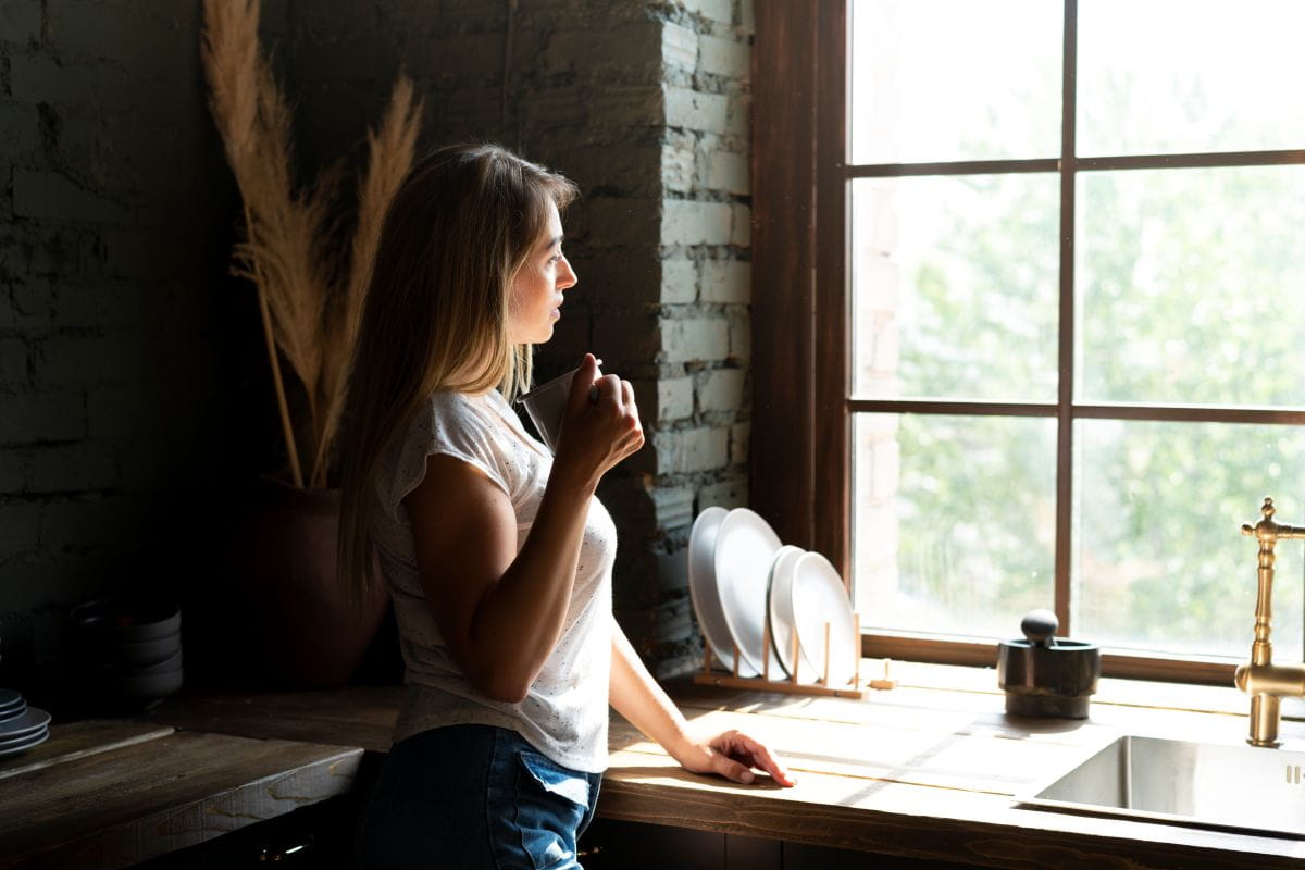 Person steht ruhig am Fenster als Symbol für Selbstliebe und innere Klarheit