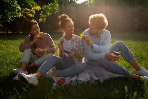 Freunde sitzen draußen und genießen gemeinsam den Sonnenuntergang im Frühling
