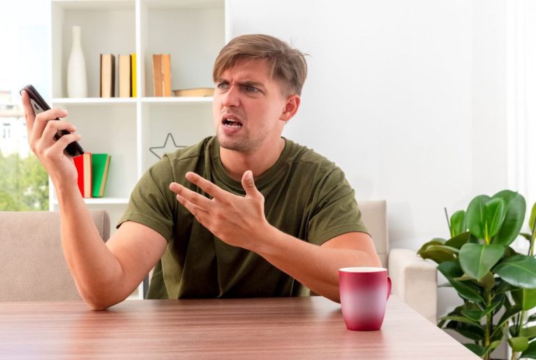 Person reagiert wütend auf Nachrichten im Smartphone