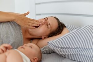 Müdes Elternteil hält Baby nach unruhiger Nacht