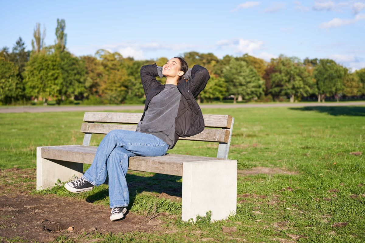 Person sitzt ruhig in der Natur während die Welt im Hintergrund schnell vorbeizieht